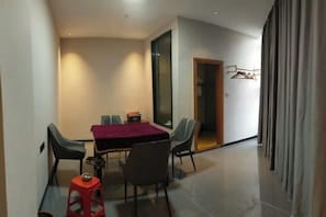 Un espace repas comprenant une table, des chaises et un petit tabouret.