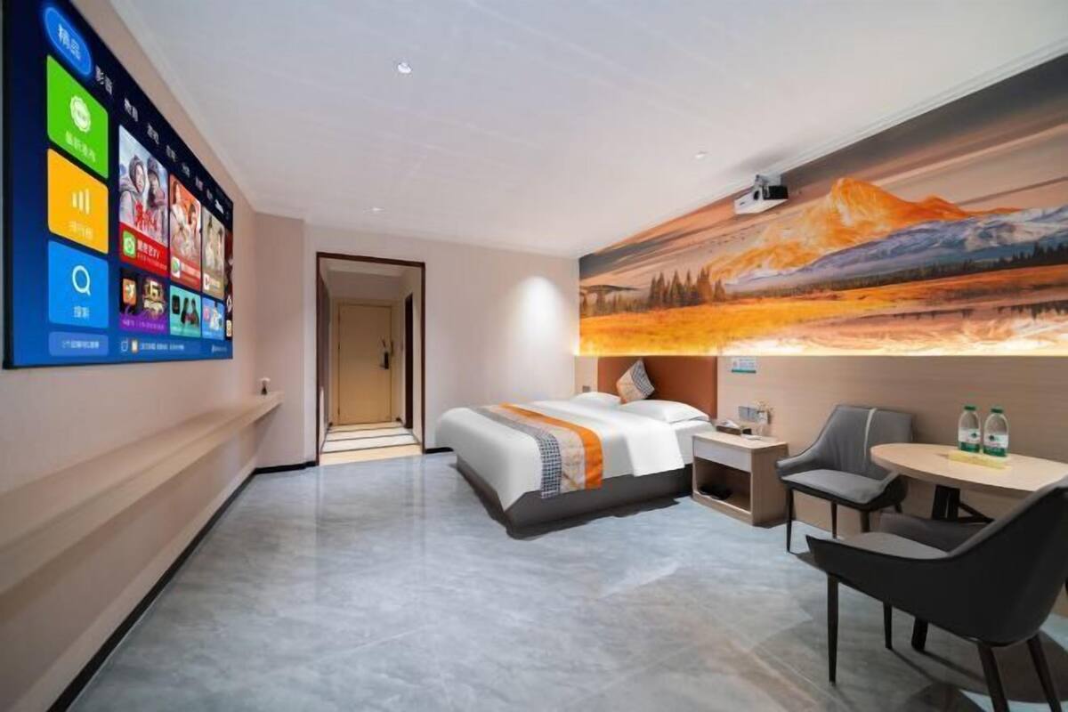 Une chambre d’hôtel moderne dotée d’un grand lit, d’un bureau et d’un coin salon.