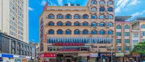 A multi-story building with a central atrium, large windows, and signage indicating commercial use.