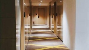 Ein Hotelkorridor mit Teppichboden und Glastüren.