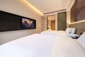 A hotel room with a large bed, a smaller bed, a wall-mounted artwork, and a door leading to another room. - Jinyunge Hotel Pingnan (Pingnan)