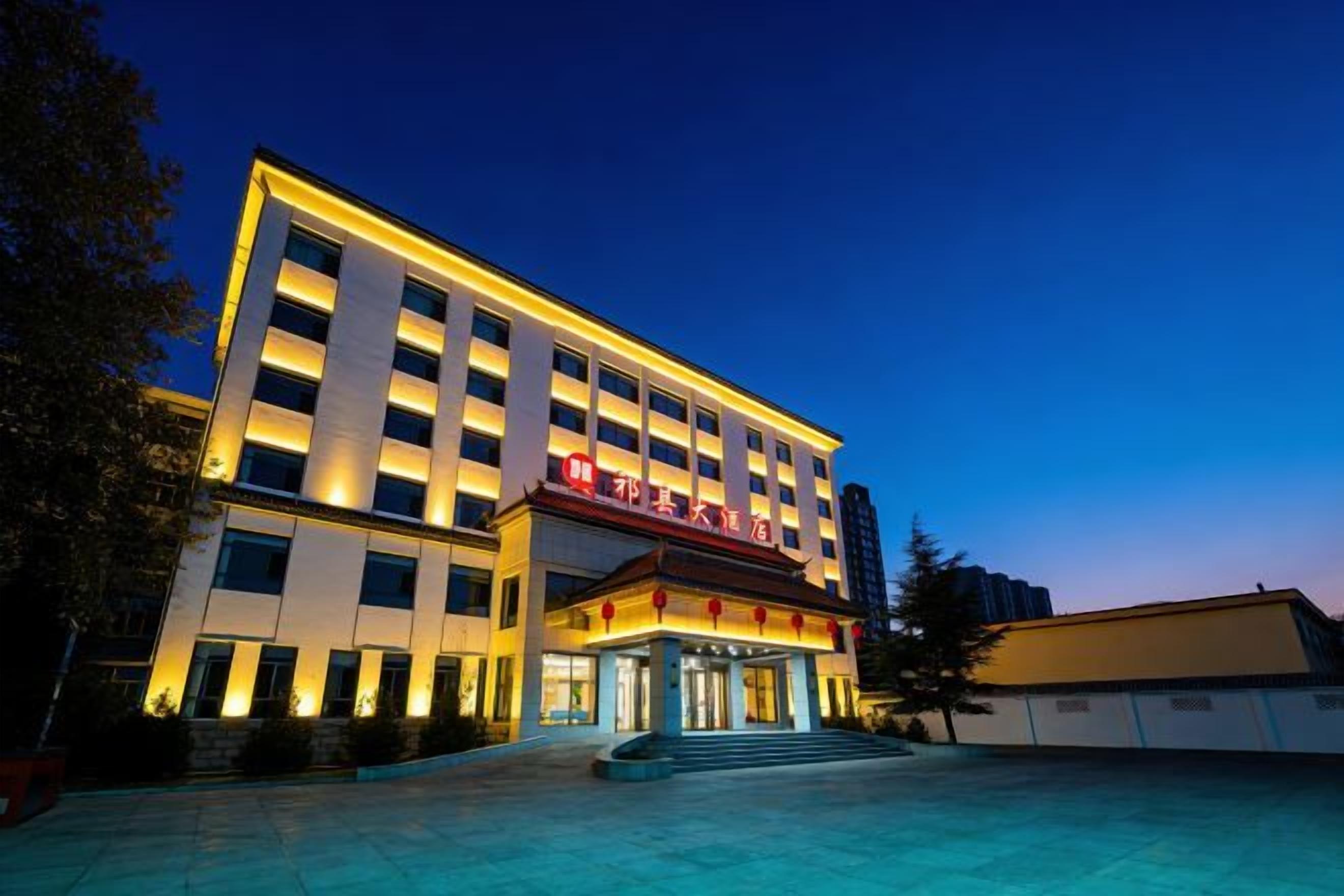 A multi-story hotel with a prominent entrance and a well-lit facade.