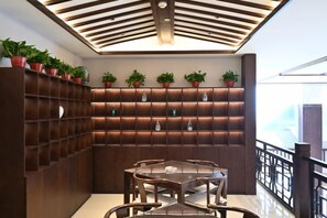 A modern interior with a wooden wall unit, a glass table, and chairs. - Qixian Hotel (Qi County)