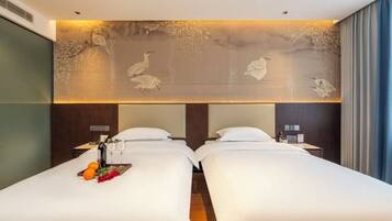A hotel room with two beds, a mural on the wall, and a view of the sea.