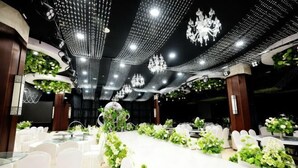 A banquet hall with round tables, white chairs, and floral centerpieces. - Qixian Hotel (Qi County)