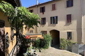 Une cour intérieure avec un bâtiment doté de nombreuses fenêtres et d’une arche.