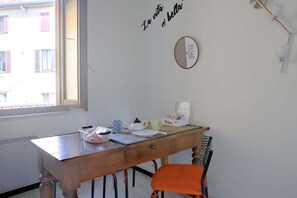 Une pièce comprenant un bureau en bois, une chaise, une fenêtre et un mur orné d’une citation inspirante.