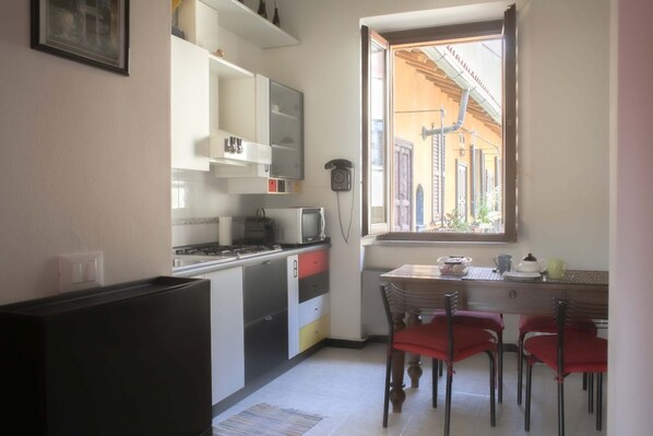 Une cuisine compacte avec un coin repas, une fenêtre offrant une belle vue et un téléphone fixé au mur.