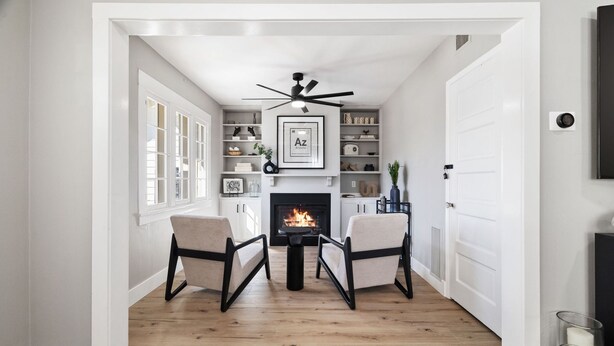 A cozy living room with a fireplace, two armchairs, and a ceiling fan. - Emma s Manor A Down Town Prescott Gem (Prescott)