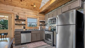 Une cuisine moderne avec des meubles en bois, des appareils électroménagers en acier inoxydable et une grande fenêtre.