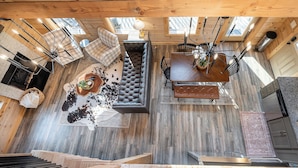 Un vaste espace de vie aménagé dans un style industriel, avec un grand canapé, une table à manger et de nombreux sièges.