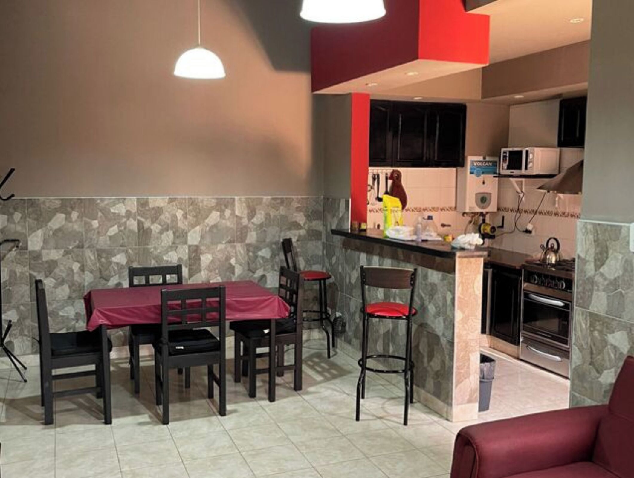 Una cocina compacta con microondas, horno y una pequeña isla con pileta.