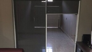 A room with a sliding door leading to a hallway, a red sofa, and a dark wooden cabinet. - CASA LUNA - Complete lodging (Salta)