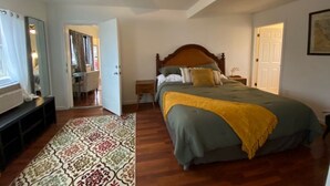 Une chambre à coucher avec un lit, un ventilateur de plafond, une table de chevet et une fenêtre.