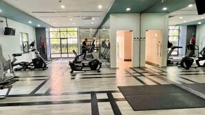 Een fitnessruimte met loopbanden, hometrainers en krachttoestellen.