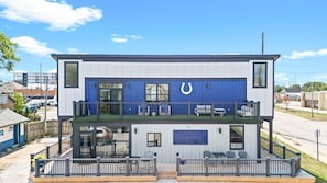 Un bâtiment à deux étages aux couleurs bleu et blanc, dont la façade est ornée d’un grand symbole en forme de fer à cheval.