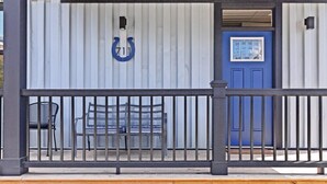 A covered outdoor seating area with a bench and a metal railing.