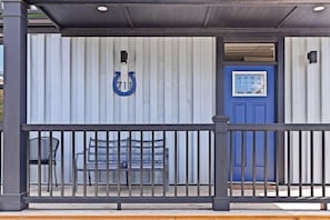 A covered outdoor seating area with a bench and a metal railing. - Awesome Custom Built Home. Perfect Indy Location! (Indianapolis)