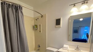 A bathroom with a bathtub, toilet, and sink. - Charming Room 5 in the St. Maries Inn (Saint Maries)