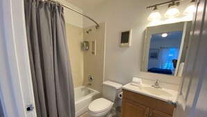 A bathroom with a bathtub, toilet, and sink. - Charming Room 5 in the St. Maries Inn (Saint Maries)