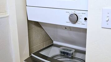 A compact, white, front-loading washer and dryer unit with a control panel featuring various settings.