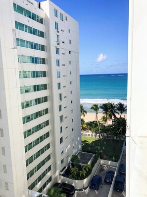 A high-rise hotel with a view of the beach and ocean.