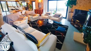 A modern living room with a fireplace, comfortable seating, and a view of the outdoors.