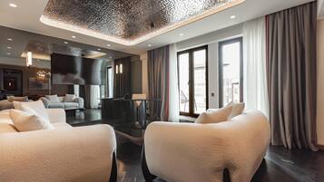 Suite, 1 cama King size | Área de sala de estar | Televisión de pantalla plana de 55 pulgadas con canales por cable