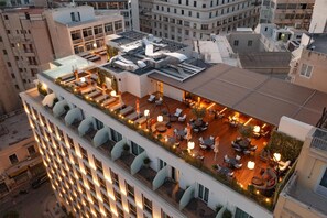 Une terrasse sur le toit avec des sièges extérieurs, une piscine et une vue sur le paysage urbain.