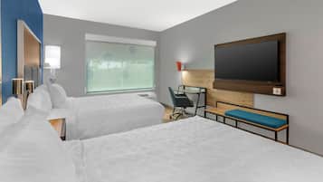 Habitación de hotel con dos camas, un escritorio, una silla, un televisor y una ventana con persianas.