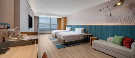 Une chambre d’hôtel moderne équipée d’un grand lit, d’un canapé, d’un bureau et d’une télévision.