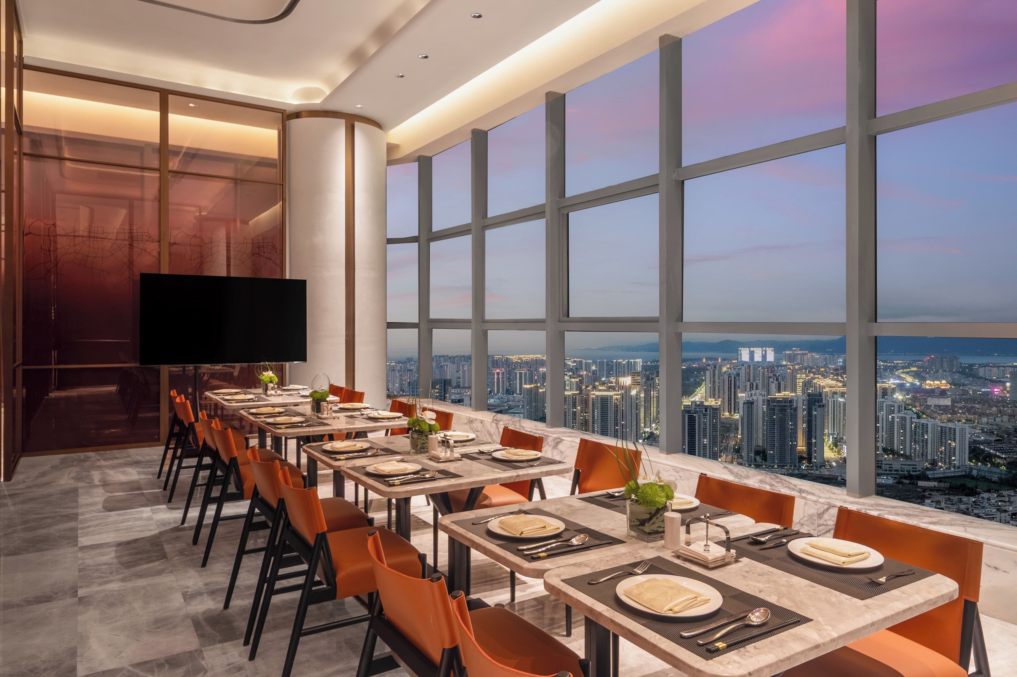 A dining area with a city view, large windows, and modern decor.