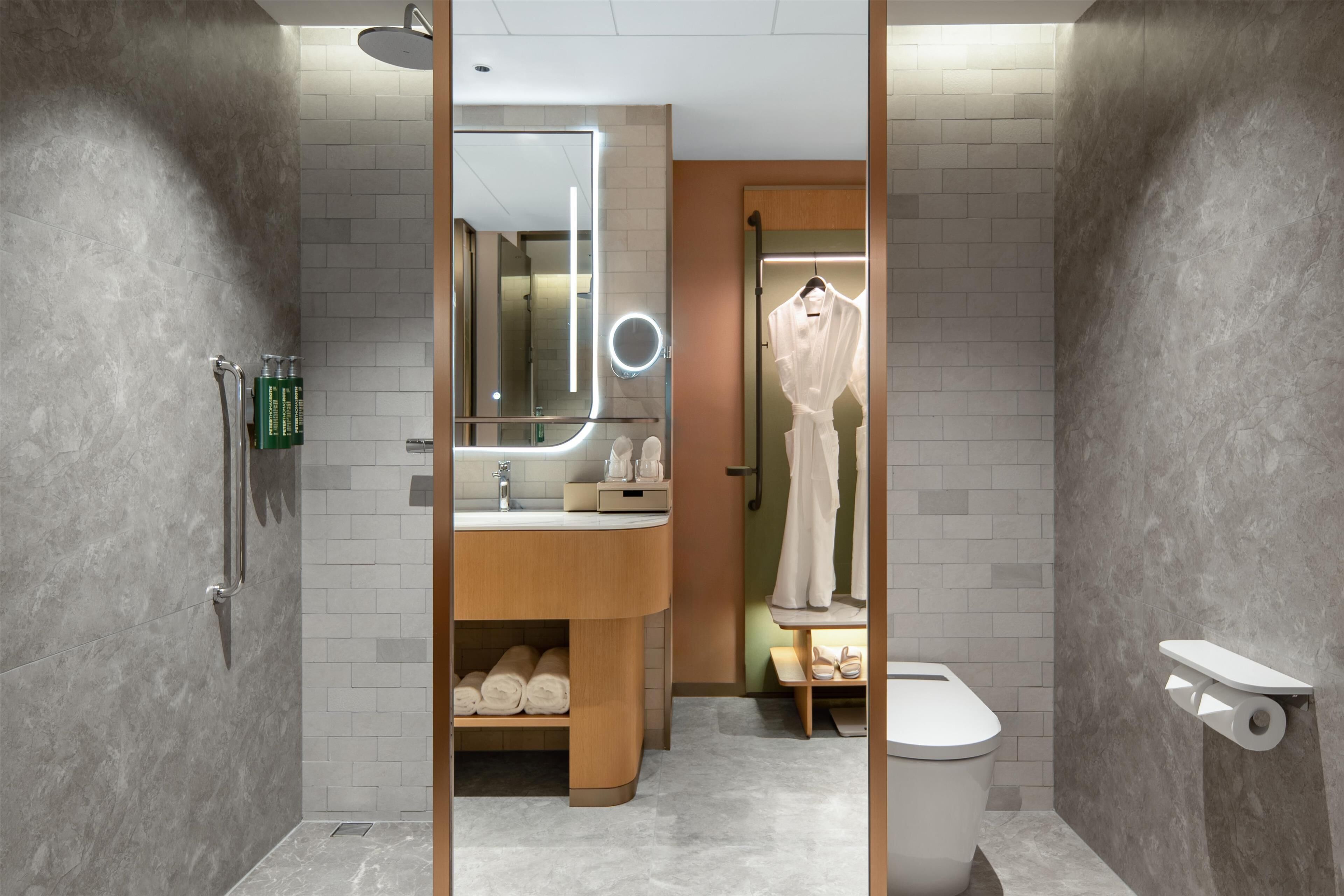 Un baño moderno con tocador, espejo y retrete.