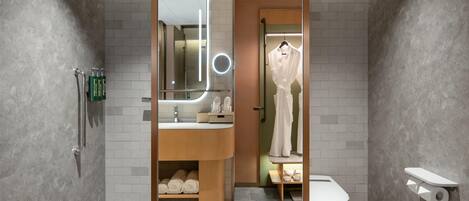 Un baño moderno con tocador, espejo y retrete.