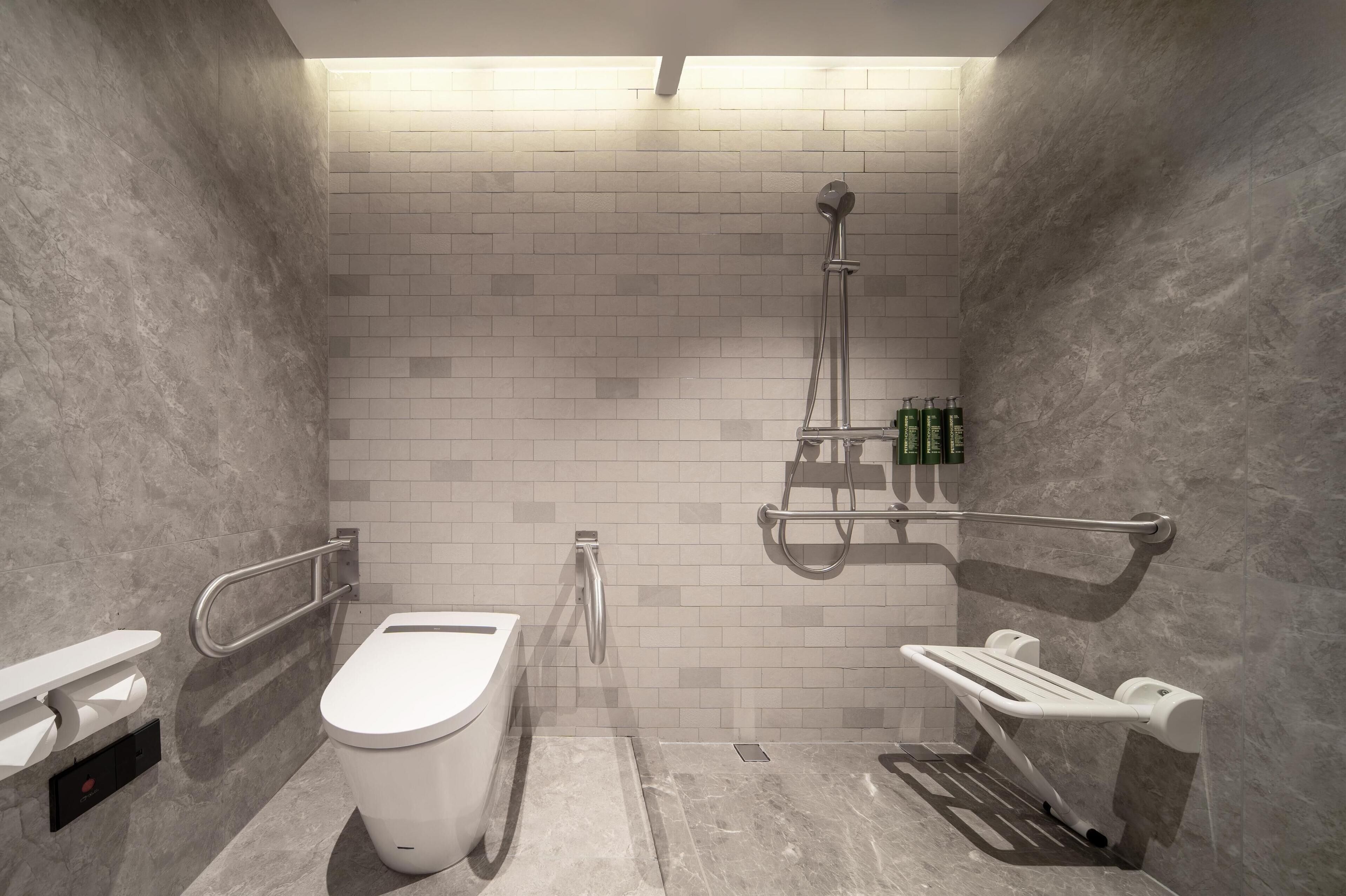 A modern bathroom with a toilet, bidet, and shower.