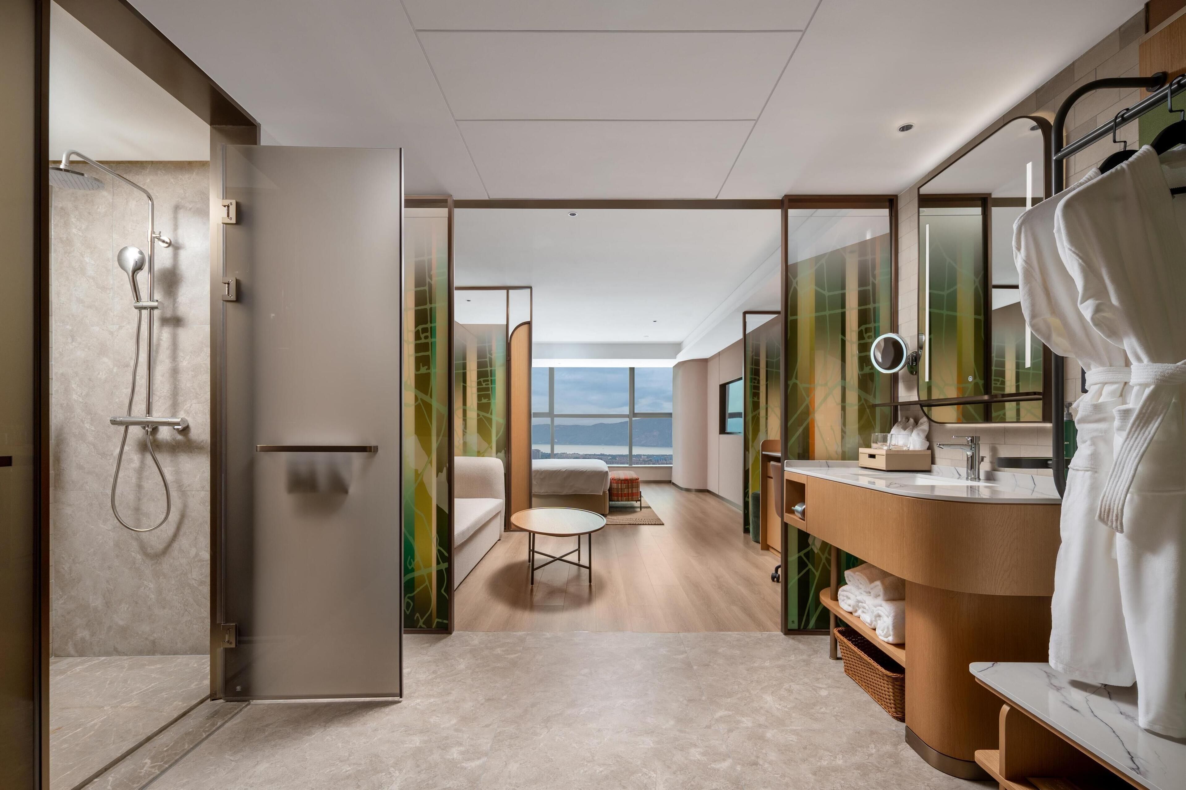 A modern bathroom with a shower, vanity, and a view of the outdoors.