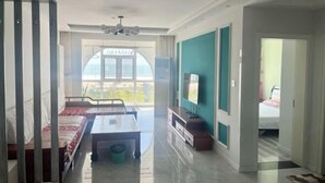 Amplia sala de estar con sofá, una mesa de centro y televisor. Cuenta con un balcón y vistas.