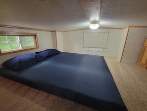 A bedroom with a bed, a window, and a ceiling fan. - Rental Cabin #404 w/ Queen bed (Wisconsin Dells)