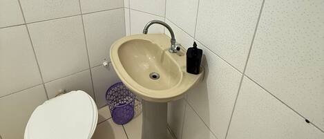 A small bathroom with a toilet, sink, and mirror.