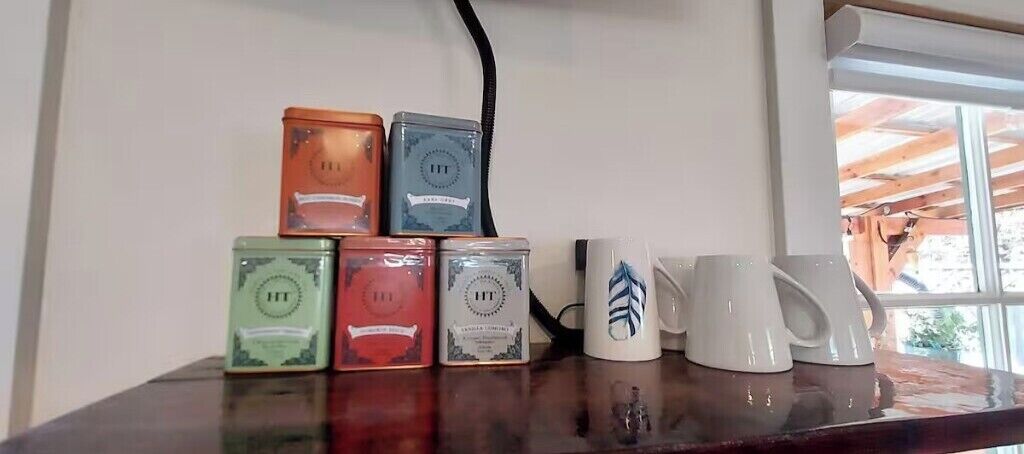 A table with six containers and a white mug.