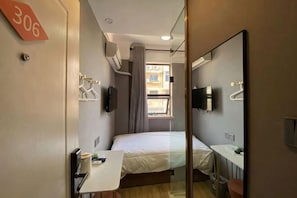 A hotel room with a bed, a desk, a mirror, a TV, and a window with curtains. - Boke Inn (Shanghai Loushanguan Road Subway Station Branch) (Shanghai)