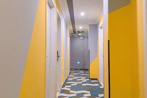 A hotel corridor with doors on both sides, a patterned floor, and a ceiling light. - Boke Inn (Shanghai Loushanguan Road Subway Station Branch) (Shanghai)