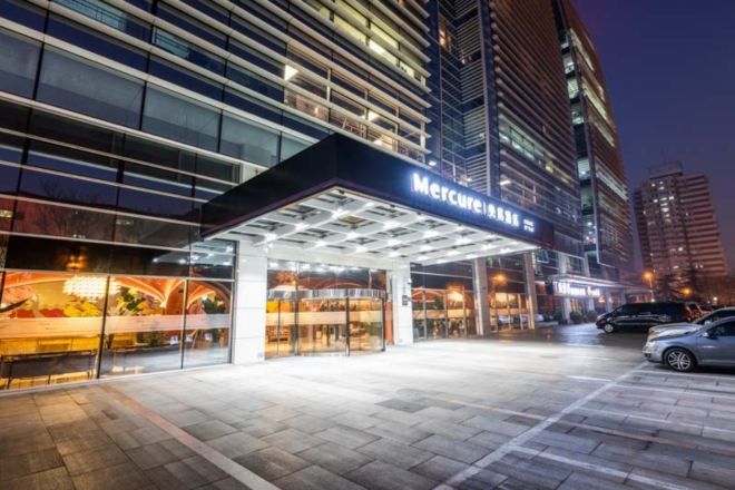 A hotel entrance with a covered walkway and a sign that reads 'Mercure'.