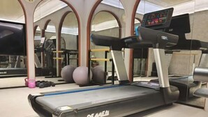 A gym with a treadmill, exercise balls, and weights.