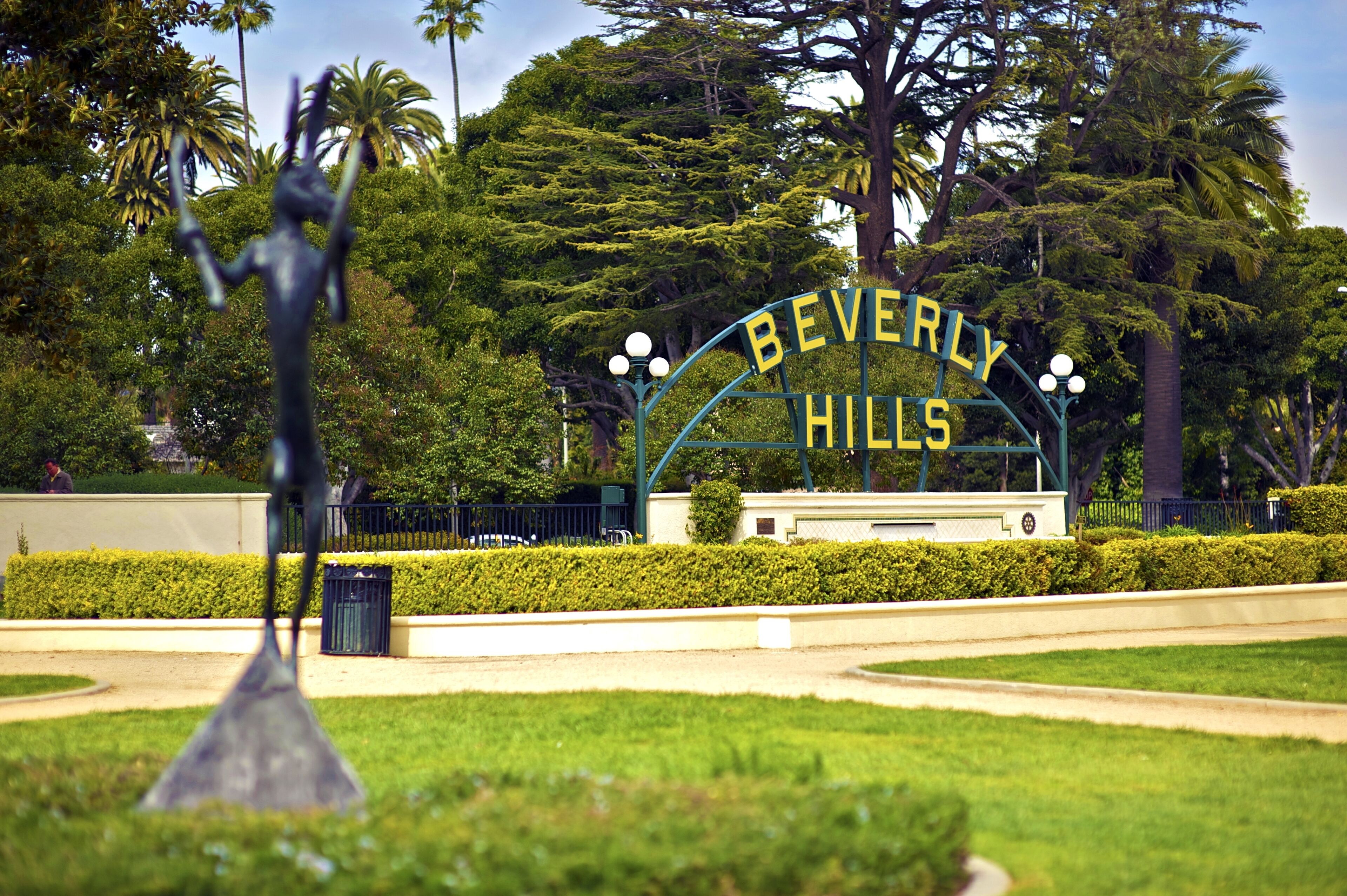 A sign for Beverly Hills with a clear view of the entrance and surrounding greenery.