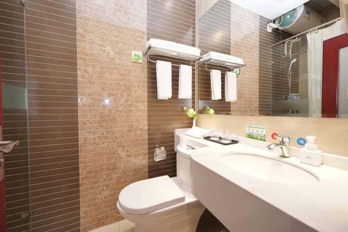 A bathroom with a toilet, sink, and mirror.