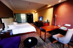 A hotel room with a bed, desk, chair, and a television. - Peninsula Hotel (Hanyuan)