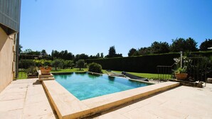 A rectangular swimming pool with a tiled deck, surrounded by a well-maintained hedge and potted plants. - The Malirel Estate (Cavaillon)