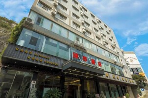 Un hotel de varios pisos con fachada moderna, ventanas amplias y una entrada destacada.