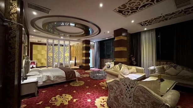 A hotel room with a bed, a sofa, a coffee table, and a decorative ceiling. - Yuanxuan Hotel (Anshun Xintiandi Food Street) (Anshun)